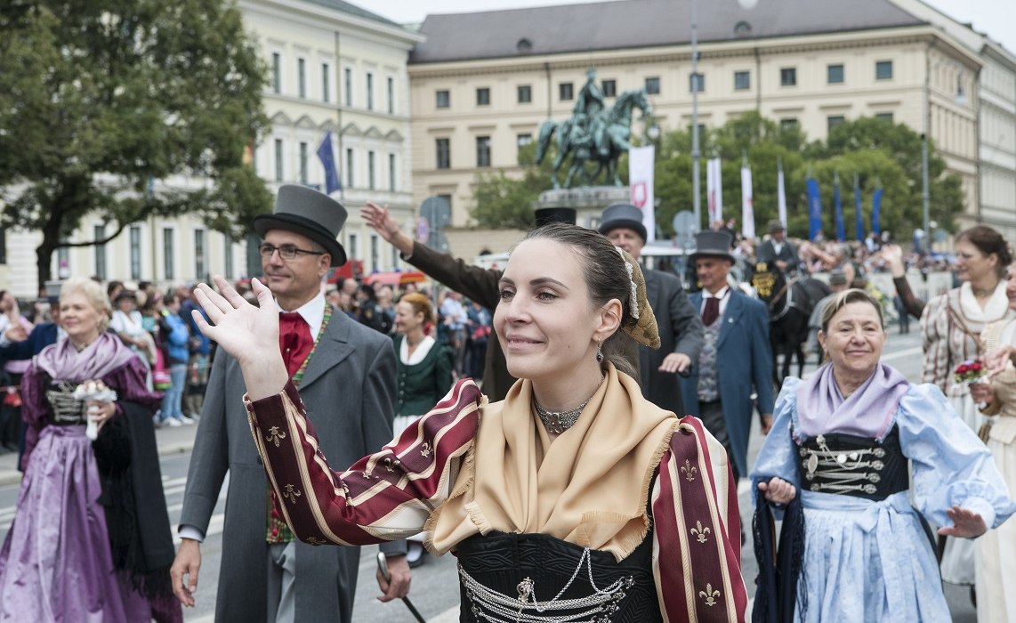 Eine Dame in Tracht winkt, © Fotostudio Liebhart