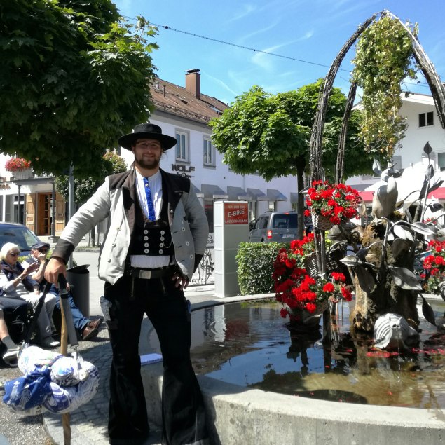 Wandergeselle Simon Freudig in voller Montur am Miesbacher MArkt, © Lisa Mayerhofer