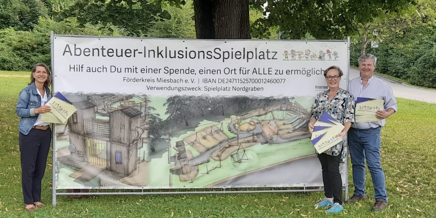 Drei Mitglieder stehen vor dem Banner des Abenteuer-InklusionsSpielplatzes, © Arbeitsgruppe InklusionsSpielplatz Drei Mitglieder stehen vor dem Banner des Abenteuer-InklusionsSpielplatzes, © Arbeitsgruppe InklusionsSpielplatz