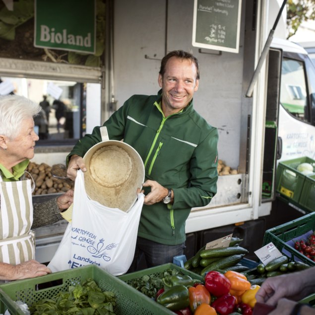 Herr Reiner schüttet Kartoffeln in eine Plastiktüte an seinem Marktstandt, © Florian Bachmeier