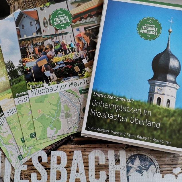 Geheime Plätze im Miesbacher Oberland mit ausgebreiteten Karten über einem Miesbach Schriftzug, © Kulturamt der Stadt Miesbach