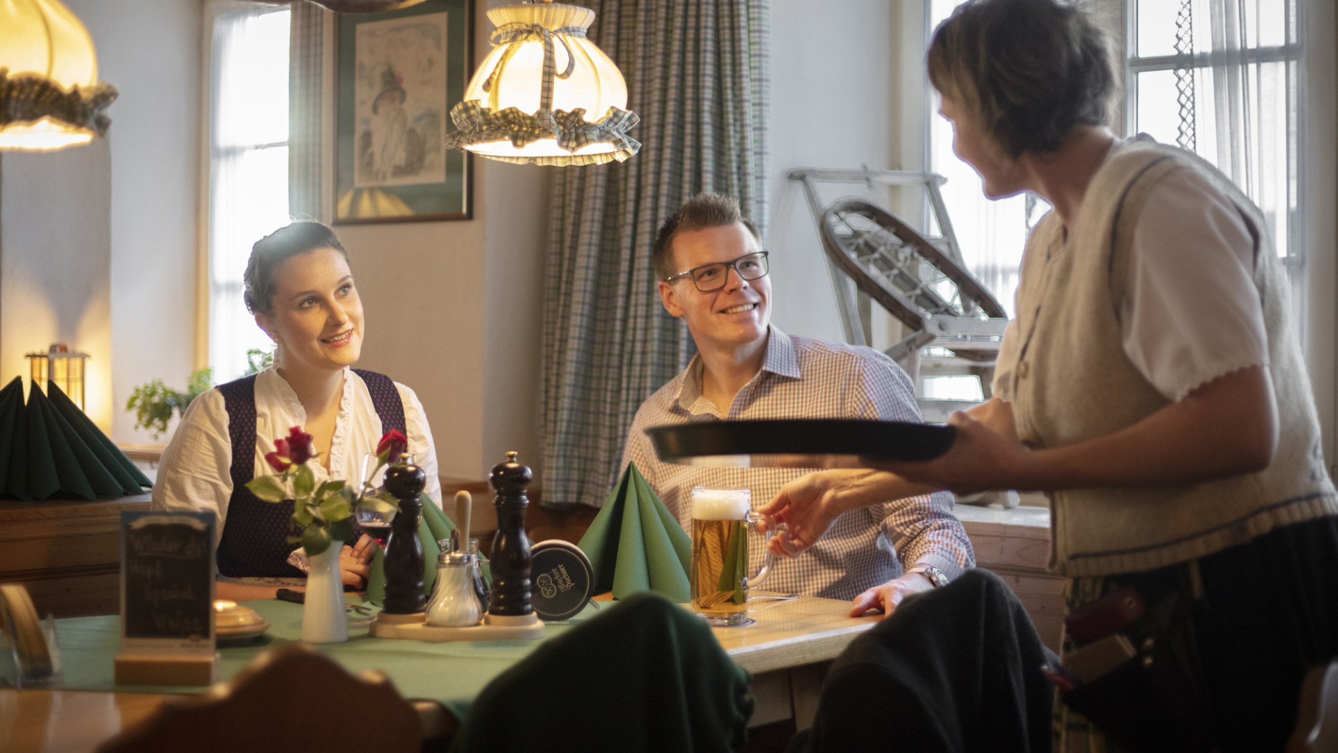 Gäste sitzen am Tisch und Bedienung spricht mit Ihnen, © Florian Bachmeier