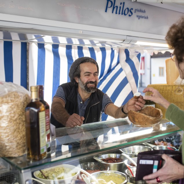 Herr Bahrami bedient eine Kundin an seinem Marktstand, © Florian Bachmeier