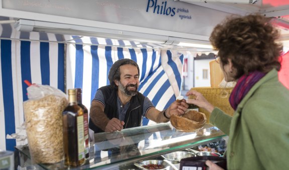 Herr Bahrami bedient eine Kundin an seinem Marktstand, © Florian Bachmeier Herr Bahrami bedient eine Kundin an seinem Marktstand, © Florian Bachmeier